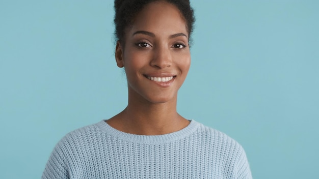 Portrait d'une belle charmante fille afro-américaine regardant joyeusement à huis clos sur fond coloré