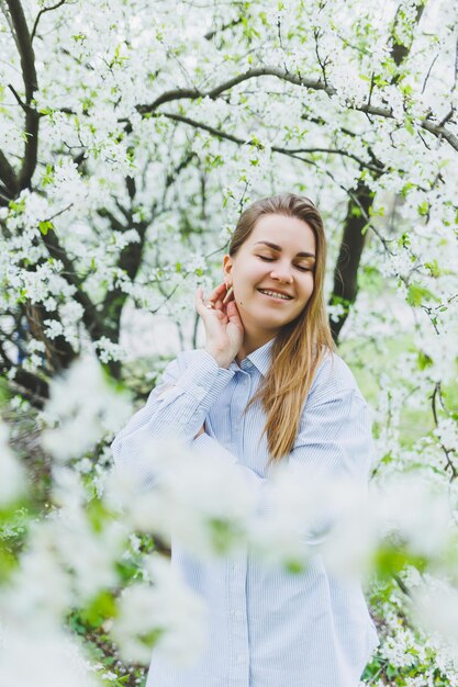 Portrait de la belle dame romantique en fleurs de pommiers