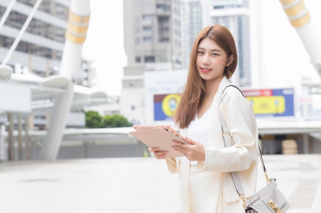 Portrait d'une belle entreprise travaillant une femme asiatique aux cheveux longs qui porte un sac à bandoulière blazer crème