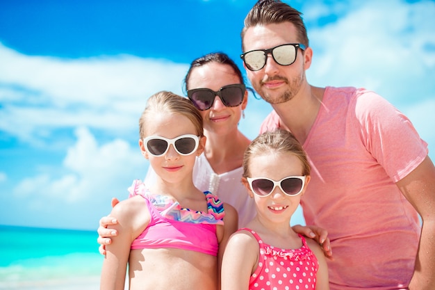 Portrait de belle famille heureuse sur la plage blanche