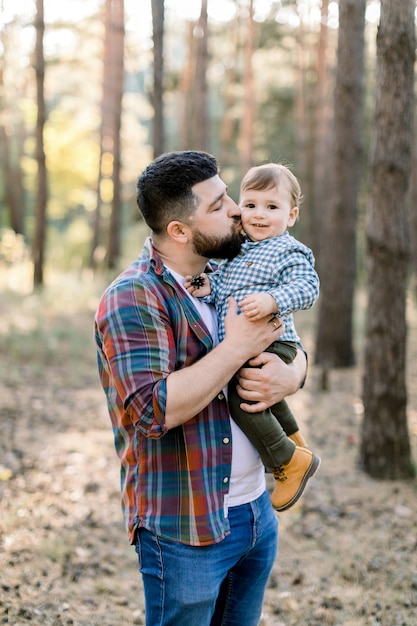 Portrait de belle famille, père et petit fils d'enfant, marchant ensemble dans la forêt de pins à l'automne