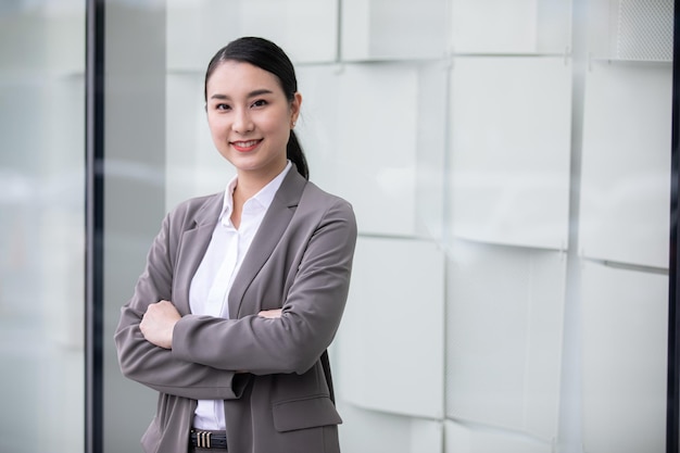 Photo portrait de la belle femme d'affaires asiatique avec les bras croisés sur un fond de bâtiment.