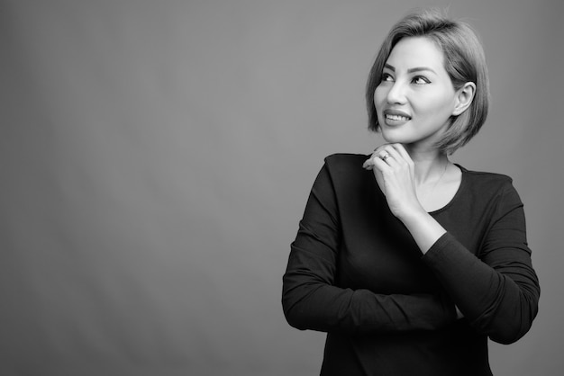 Portrait de belle femme d'affaires asiatique sur gris en noir et blanc