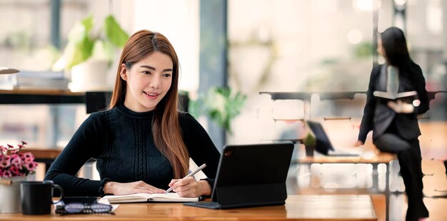 Portrait d'une belle femme d'affaires entrepreneur travaillant sur une tablette portable dans un bureau moderne.