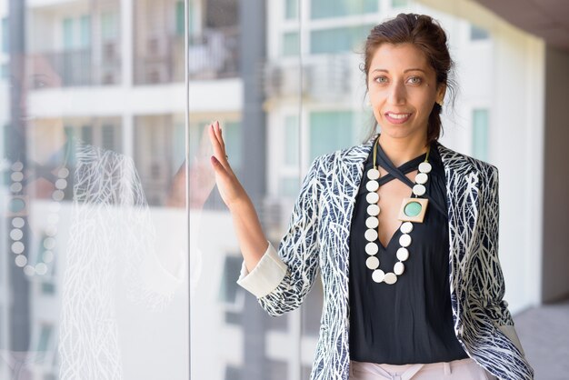 Photo portrait de la belle femme d'affaires par la fenêtre en verre de l'immeuble de bureaux à l'intérieur