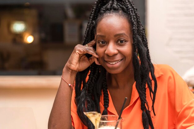 Portrait d'une belle femme afro-américaine regardant la caméra avec un verre