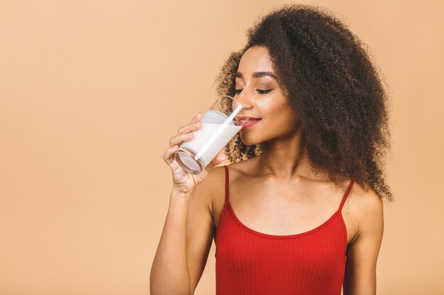 Portrait de la belle femme afro-américaine avec verre de lait