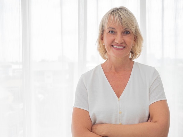 Portrait d'une belle femme d'âge moyen souriant amicalement et regardant à huis clos dans le salon Images réalistes sans retouche avec leurs imperfectionsxA