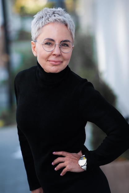 Portrait d'une belle femme âgée aux cheveux blancs et lunettes en plein air