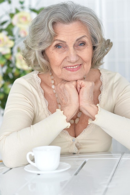 Portrait d'une belle femme âgée heureuse avec une tasse de thé