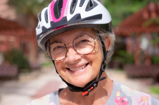 Portrait d'une belle femme âgée portant un casque de vélo en plein air Dame âgée souriante regardant la caméra