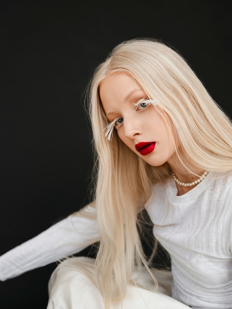 Portrait d'une belle femme albinos avec des plumes comme cils