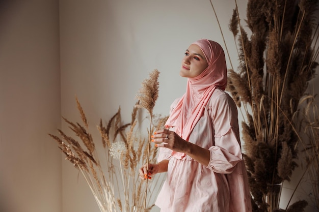 Portrait d'une belle femme arabe musulmane portant le hijab rose vue latérale