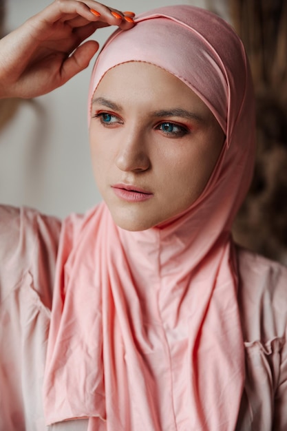 Portrait de la belle femme arabe musulmane portant le hijab rose