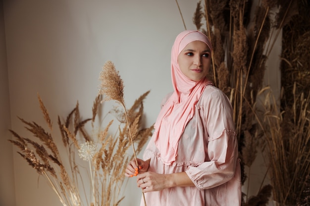 Portrait d'une belle femme arabe musulmane portant une vue latérale du hijab rose