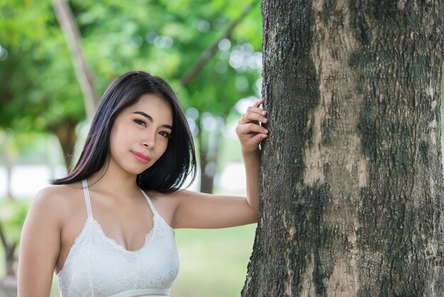 Portrait d'une belle femme asiatique cheveux noirs en plein airconcept de femme heureuseMode de vie d'une fille moderneThaïlande sur la route dans la forêt