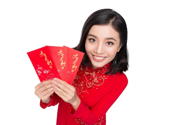 Portrait d'une belle femme asiatique en costume de festival traditionnel Ao Dai tenant une poche rouge - argent chanceux. Vacances du Têt. Nouvelle année lunaire. Texte signifie bonheur et bonheur