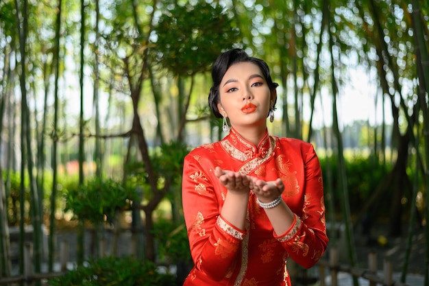 Portrait belle femme asiatique dans un cheongsam chinois étend sa paume comme espace vide pour insérer une photo pour la publicité