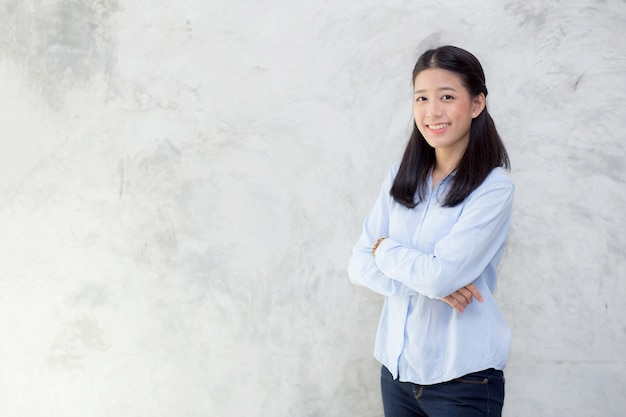 Portrait de la belle femme asiatique debout sur le mur de ciment gris texture grunge