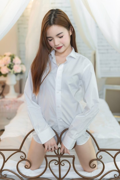 Portrait d'une belle femme asiatique portant une chemise blanche dans la chambre