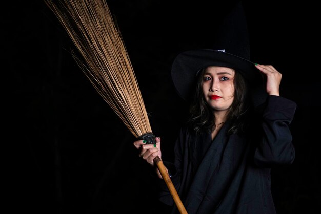 Portrait d'une belle femme asiatique portant un costume de sorcière sur fond noirThaïlande concept de festival d'HalloweenScène d'horreur