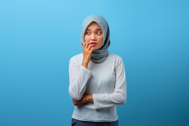 Portrait d'une belle femme asiatique semblant stressée et nerveuse avec la main sur la bouche se ronger les ongles