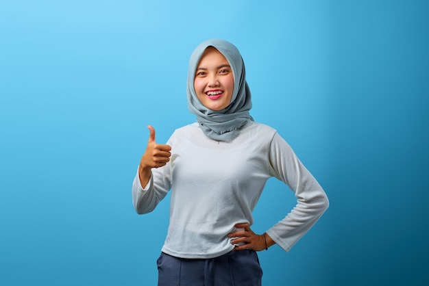 Portrait d'une belle femme asiatique souriante et montrant des pouces vers le haut ou un signe d'approbation