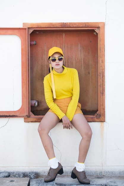 Portrait d'une belle femme asiatique en tissu jauneHipsters girl wear yellow hat take a pictureThailand people