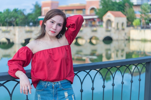 Portrait d'une belle femme asiatique à la ville toscane Les gens de Thaïlande posent pour prendre une photo peuvent voir le pont et la rivière