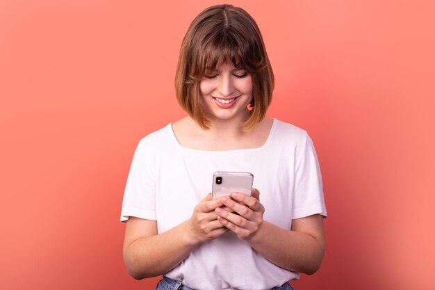 portrait d'une belle femme aux cheveux bruns assez gaie et jolie à l'aide d'un appareil numérique bavardant