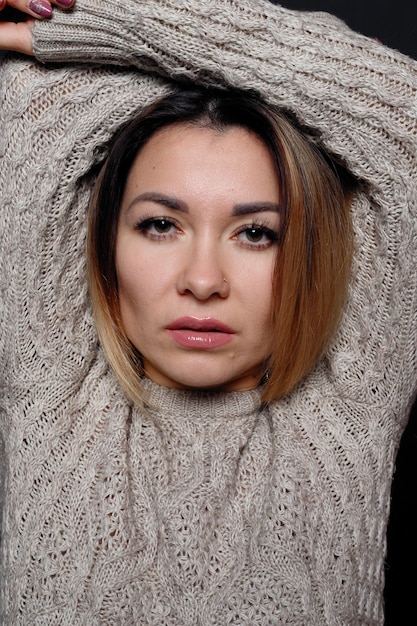 Portrait de belle femme aux cheveux rouges en pull gris chiné avec des cheveux