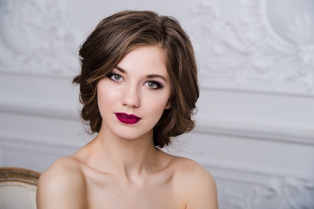 Portrait de la belle femme aux lèvres rouges à la salle intérieure de luxe