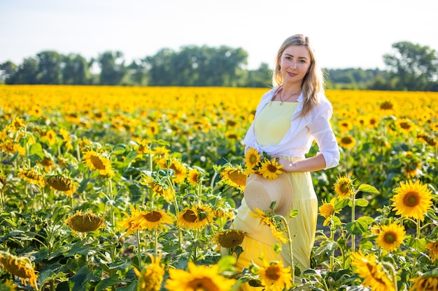 Portrait de la belle femme aux tournesols sur fond de ciel