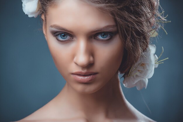 Portrait d'une belle femme avec un beau maquillage et une coiffure. À la décoration d'une grosse pierre