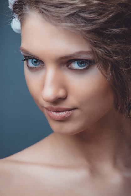 Portrait d'une belle femme avec un beau maquillage et une coiffure. À la décoration d'une grosse pierre