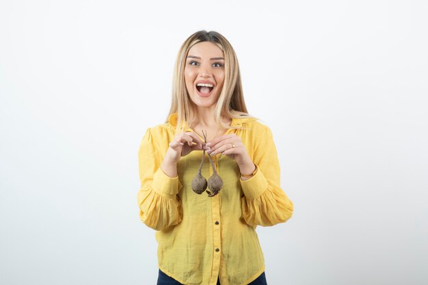 Portrait de la belle femme blonde à la betterave debout sur blanc