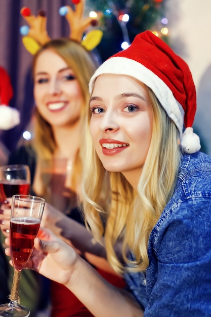 Portrait d'une belle femme blonde avec une coupe de champagne au chapeau du nouvel an