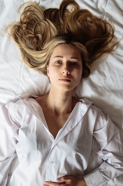 Portrait belle femme blonde dans le lit