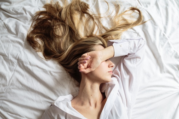 Portrait belle femme blonde dormant dans le lit