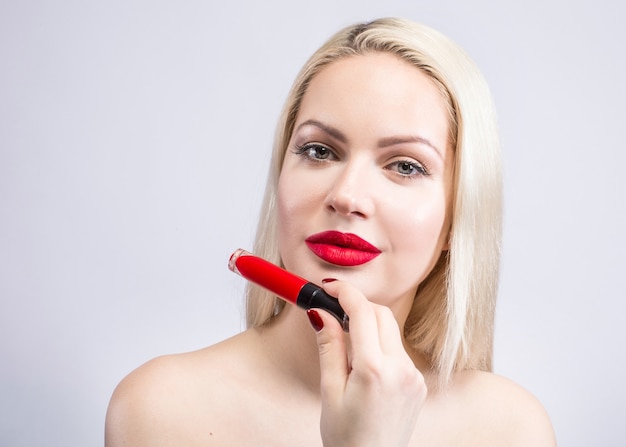 Portrait de la belle femme une blonde avec du rouge à lèvres rouge