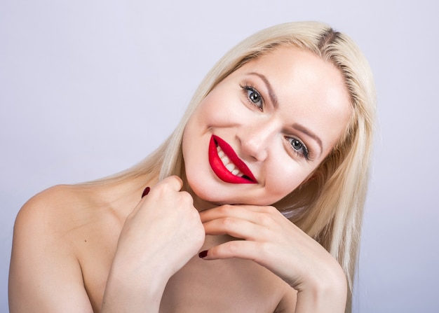 Portrait de la belle femme une blonde avec du rouge à lèvres rouge