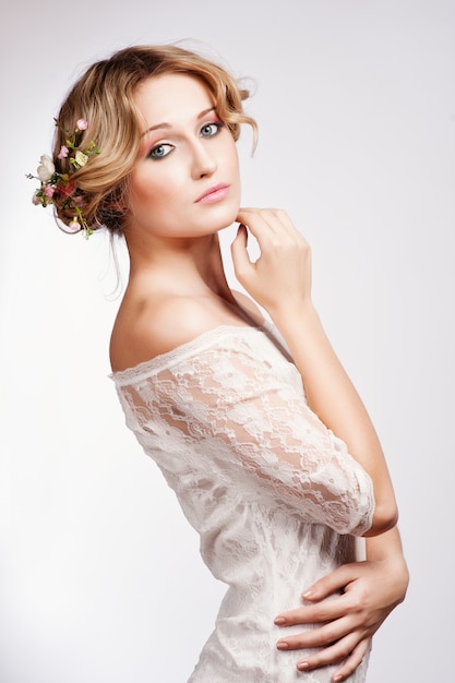 Portrait d&#39;une belle femme blonde avec des fleurs dans les cheveux.