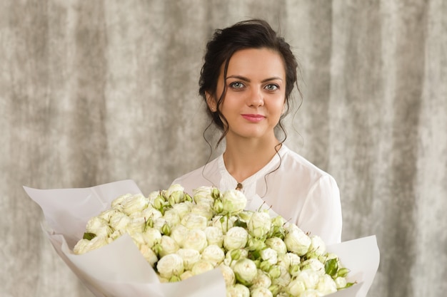 Portrait d'une belle femme brune avec un bouquet de fleurs de tulipes