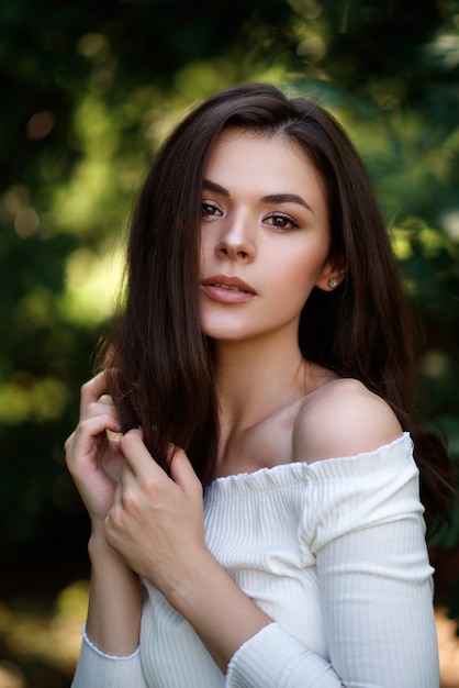 Portrait de la belle femme brune dans le parc d'été