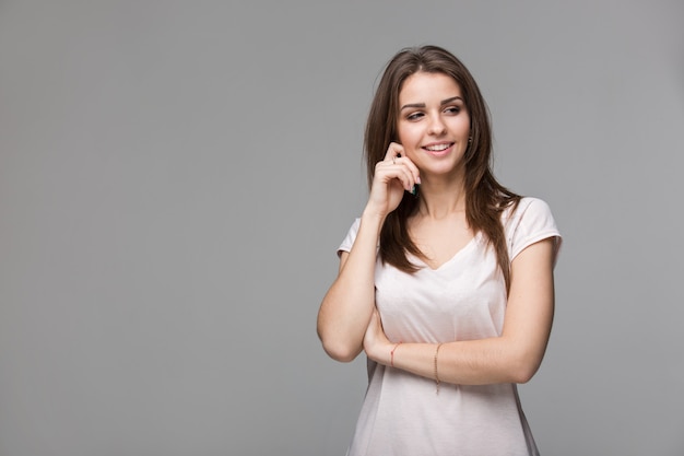 Portrait de belle femme brune avec du maquillage naturel sur fond gris