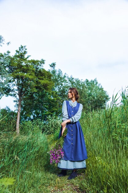 Portrait d'une belle femme brune en robe bleue dans le domaine