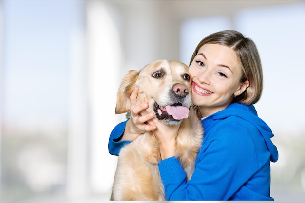 Portrait de belle femme avec chien sur fond clair flou