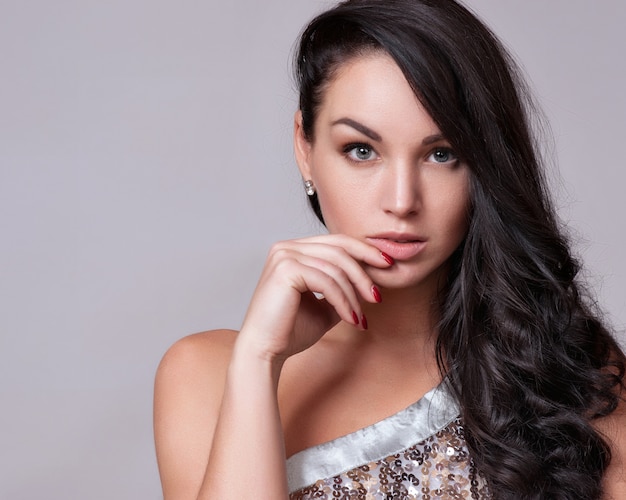 Portrait de belle femme avec une coiffure frisée et maquillage lumineux