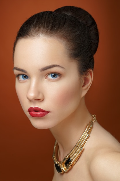 Portrait de la belle femme avec des colliers dorés autour du cou