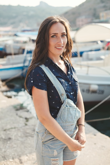 Portrait d'une belle femme contre une jetée en bois et yachts